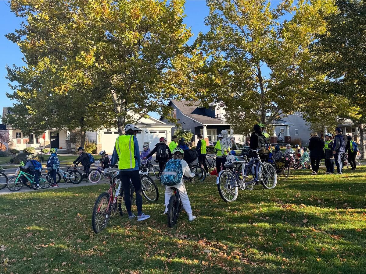 Kids and adults with bikes gathered together before a group ride